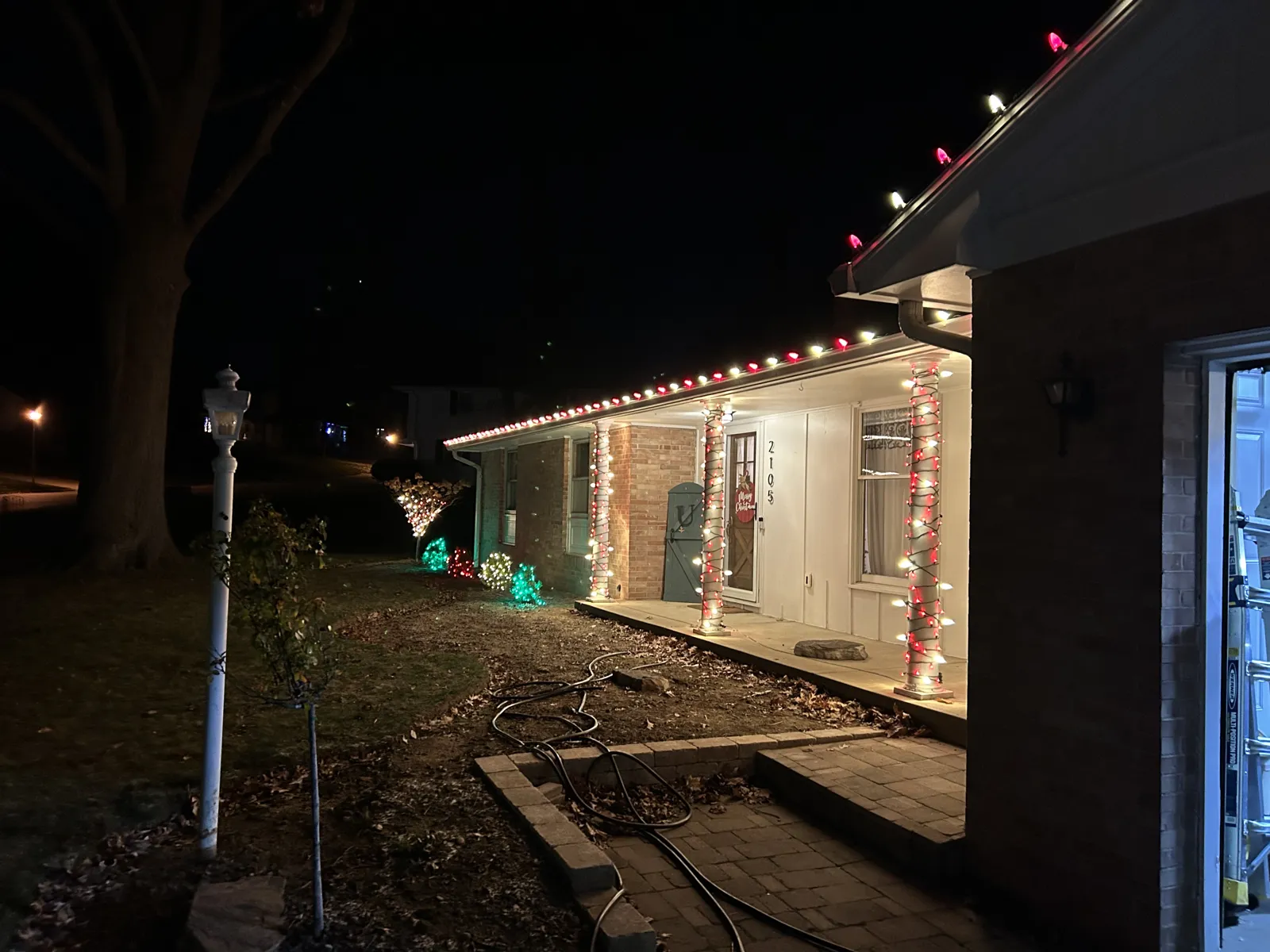 Ranch porch lined with warm-white Christmas lights at night