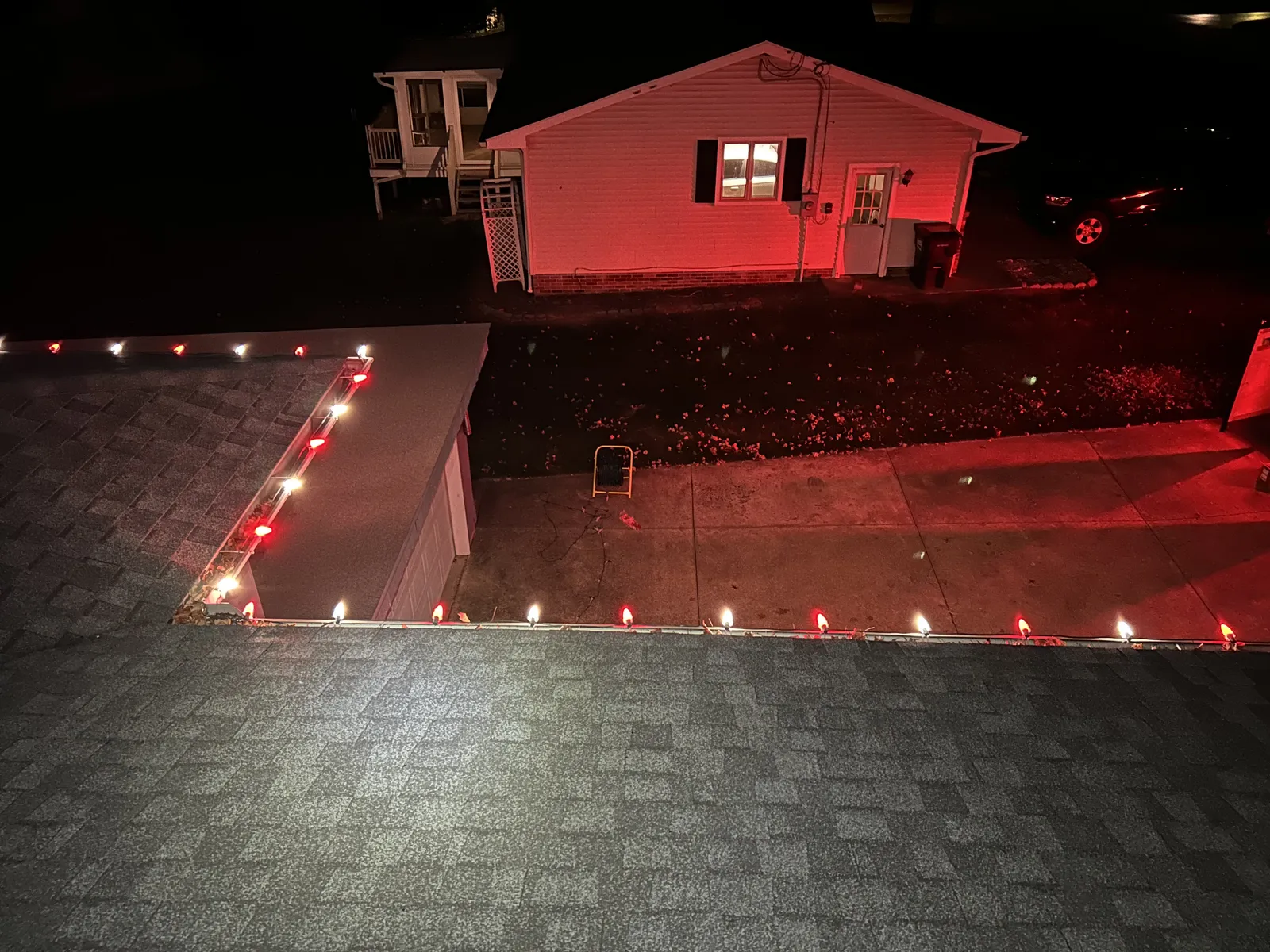 Home with red and warm-white roofline lights at night