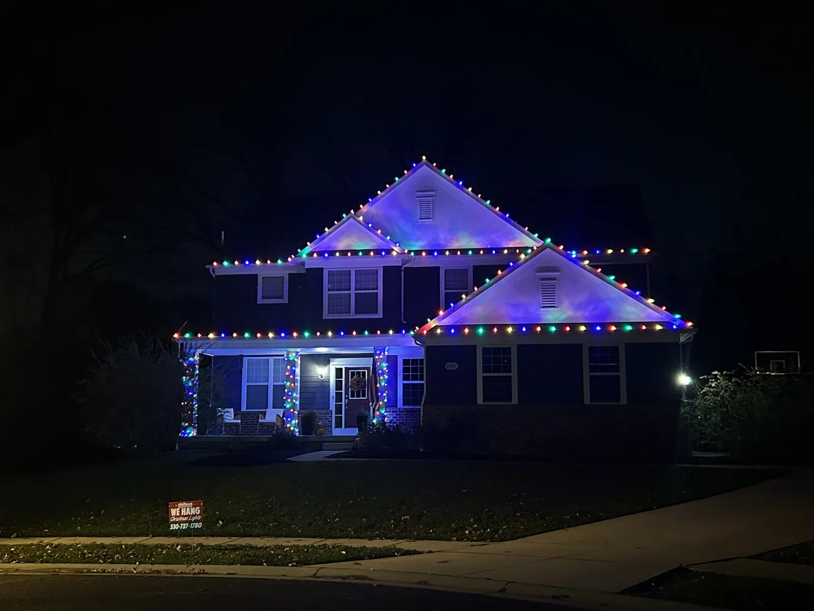 Two-story home with multi-color C9 lights outlining every gable