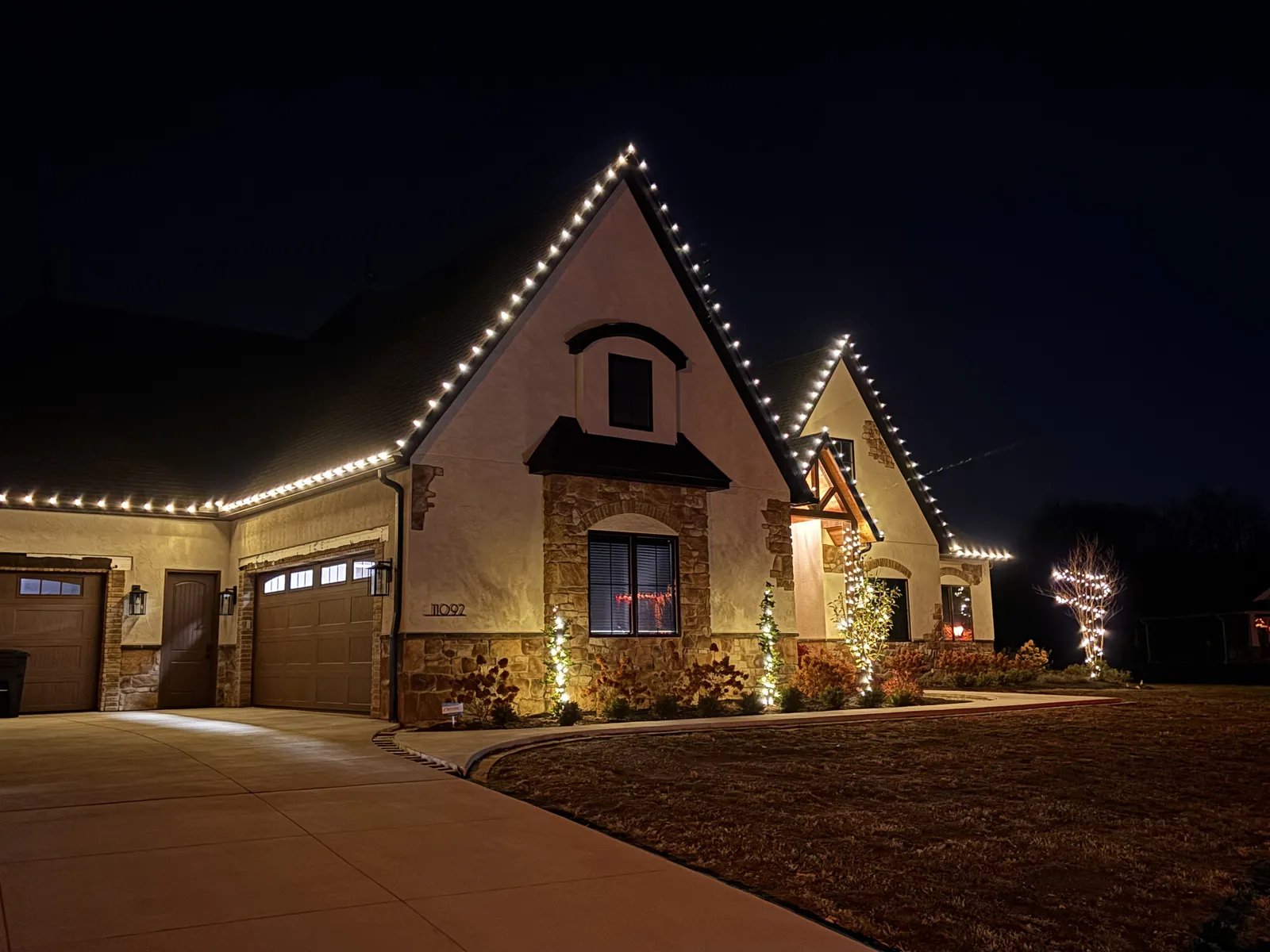 Tan home outlined in warm-white roofline lights at night