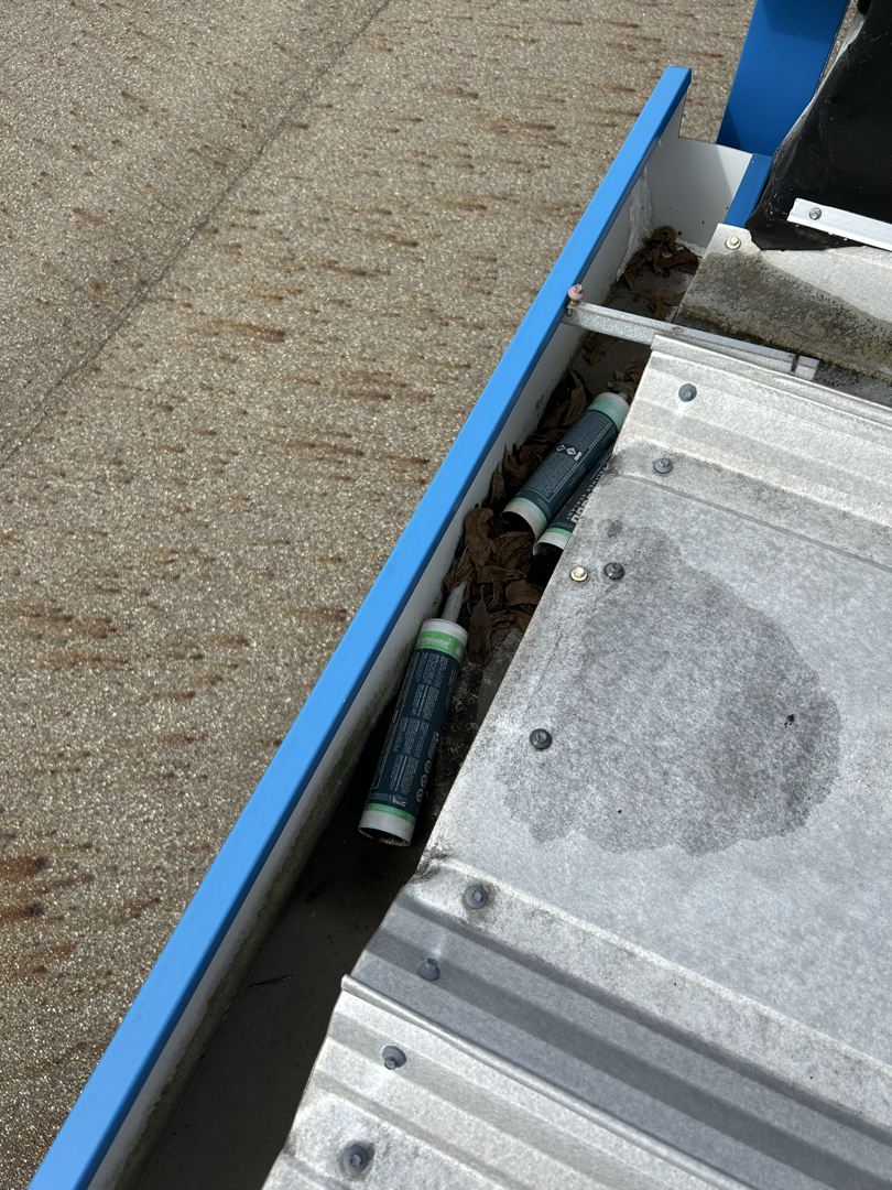Leaves and discarded caulking tubes found inside a commercial gutter