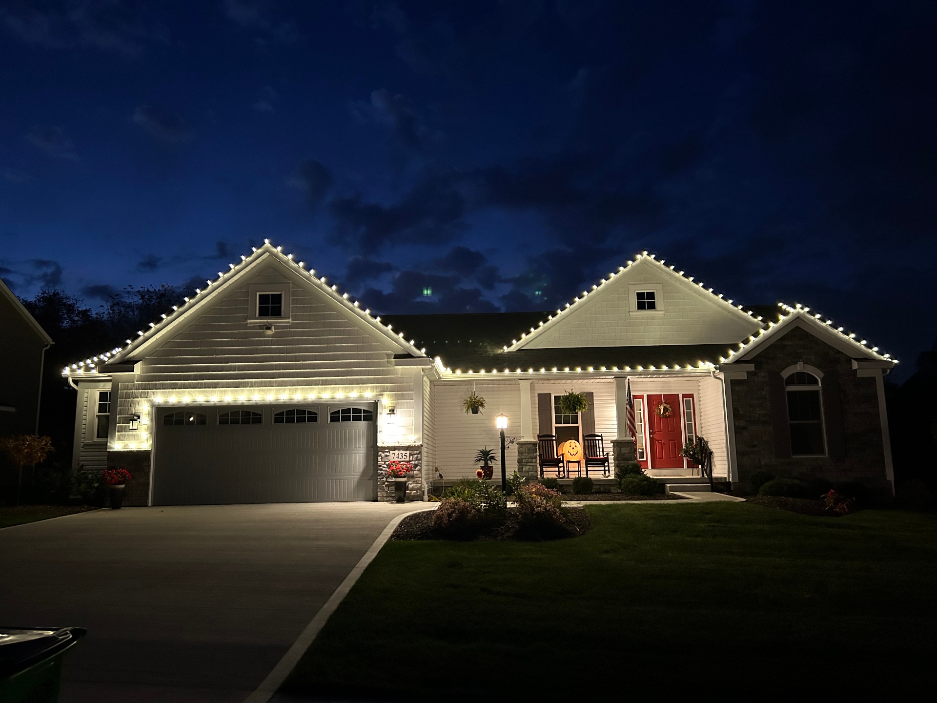 Ranch home decorated with red, white, and blue holiday lights