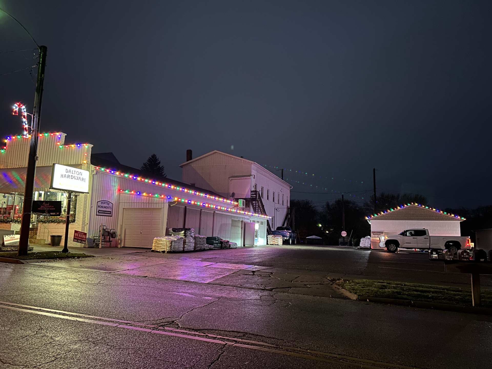 Two-story home with festive white and red seasonal Christmas lights in snow