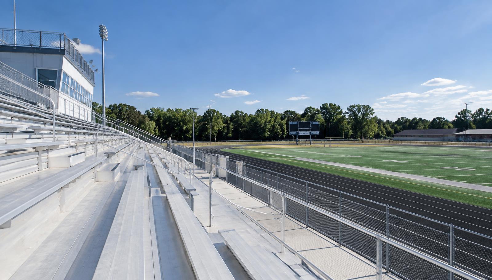 Clean aluminum stadium bleachers at a high school athletic field after pressure washing